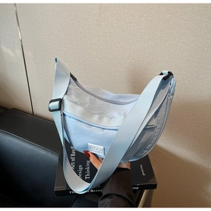 Gros plan du sac bandoulière croissant en nylon bleu clair avec logo et sangle réglable
