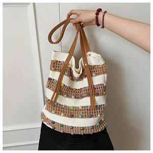 Détail du sac cabas tissé à rayures avec perles colorées et poignée en cuir marron