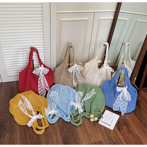 Détail de sacs fourre-tout ajourés au crochet avec de grands nœuds en dentelle blanche