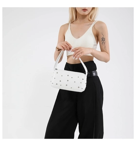 Macro detail of white rivet handbag featuring silver metallic studs and smooth PU leather
