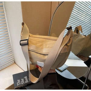Vue détaillée du sac hobo en toile kaki avec bandoulière réglable et logo carré