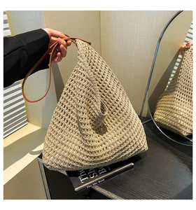 Detail of hollow woven beach tote with white lining and brown leather handles