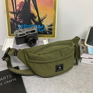 Close-up of olive green nylon fanny pack with adjustable strap and brand logo label