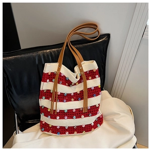 Détail du cabas crocheté rayé avec perles colorées et anses en cuir marron de qualité