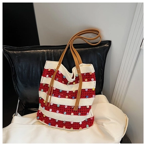 Détail du sac cabas en maille rayée rouge et blanc avec perles et anses en cuir