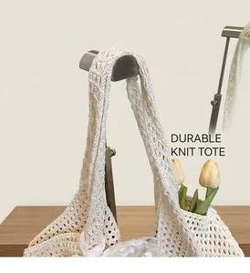 Gros plan du sac cabas en maille tressée crème avec motif ajouré et tulipes décoratives