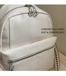 Close-up of white lychee texture backpack with silver metal zippers and woven straps