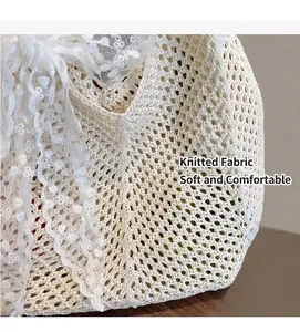 Détail d'un sac cabas en maille beige avec nœud en dentelle et texture ajourée crochetée