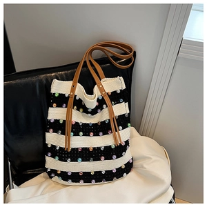 Détail du sac cabas en tricot rayé avec perles colorées et anses en cuir marron