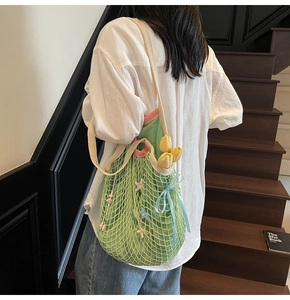 Detail view of woven knit tote bag with pink trim and shoulder strap on model
