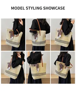 Detail view of large straw tote bag with black stripes and brown leather strap on model