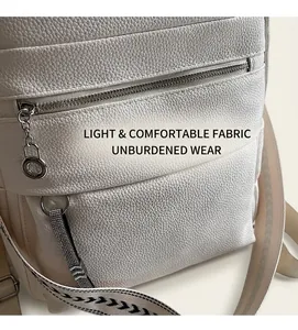 Detail of white lychee leather texture on a backpack with silver metal zipper and ring