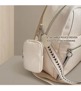 Detail of detachable coin purse on cream pebbled leather backpack with patterned strap
