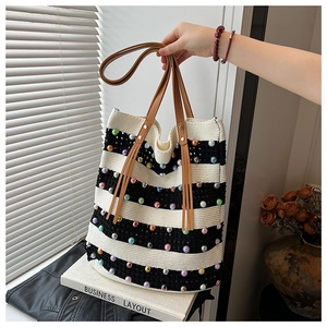 Détail d'un sac cabas en maille rayée avec perles colorées et poignées en cuir souple