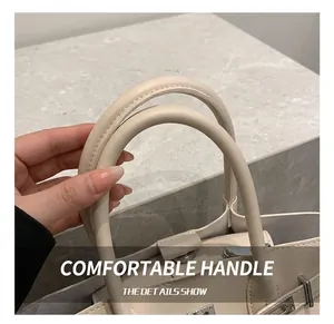 Gros plan sur l'anse en cuir crème d'un sac avec des détails de couture précis