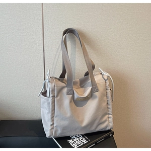Vista dettagliata della borsa tote grigia in nylon con tasche laterali e zip superiore