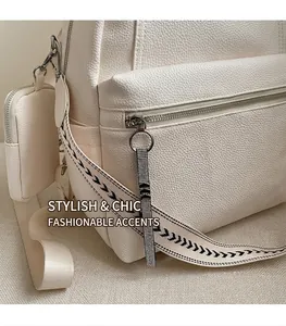 Detail of off-white lychee leather backpack with crystal zipper pull and woven strap
