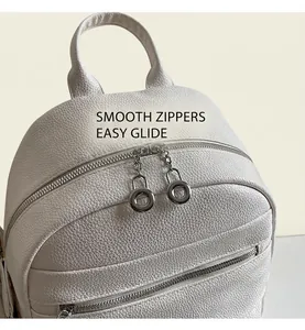 Detail of white lychee pattern backpack with smooth dual metal ring zippers and top handle