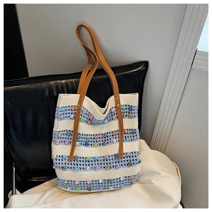 Détail du sac cabas tricoté à rayures avec des perles colorées et des anses en cuir marron