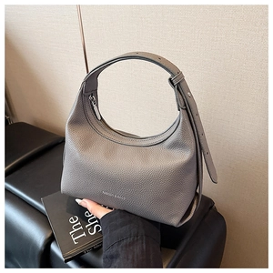 Detail shot of grey pebbled leather dumpling bag with Fashion & Bags silver zip text