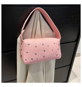 Detail of pink baguette bag featuring silver studs and lychee pattern texture
