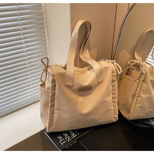 Dettaglio del lato arricciato con coulisse sulla borsa beige con logo Buduo Fashion