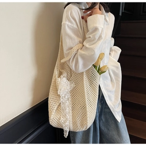 Détail du sac cabas au crochet avec nœud en dentelle blanche et texture ajourée