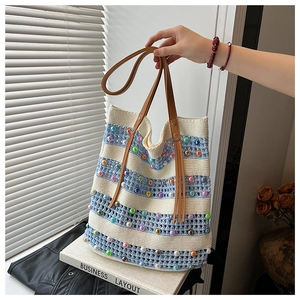 Détail du sac cabas au crochet à rayures bleues et blanches avec perles et anses en cuir