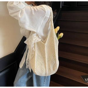 Détail du sac fourre-tout au crochet crème avec nœud en dentelle et texture maille douce