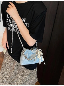 Blue denim drawstring bucket bag with pearl chain and white lace bow detail