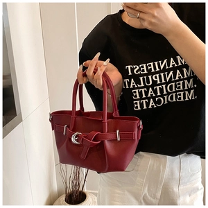 Détail du sac seau bordeaux avec boucle métallique et lanière à nœud élégante