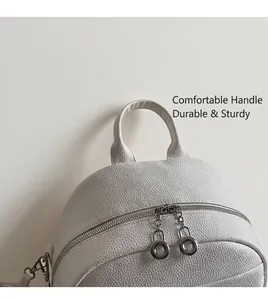 Close-up of white lychee leather backpack showing top handle and silver double zippers