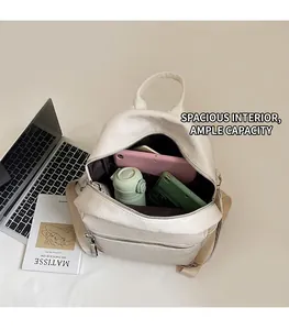 Detailed view showing large capacity of the white leather backpack with daily essentials