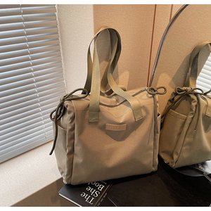 Dettaglio della borsa tote kaki con tasche a coulisse e ampi spallacci per il trasporto