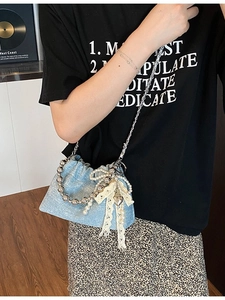 Light blue sequin bucket bag with silver large bead handle and pearl bow detail