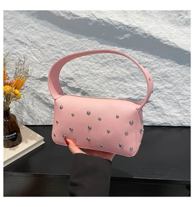 Detail of pink lychee textured faux leather bag with silver studs and zipper closure