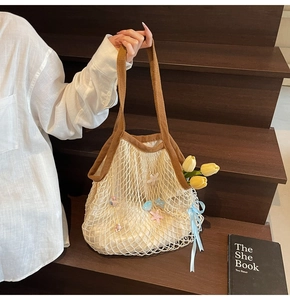 Detail of woven tote bag featuring starfish charms, blue ribbon and silk inner liner