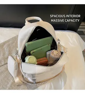 Spacious white pebbled leather backpack showing interior storage with laptop and accessories