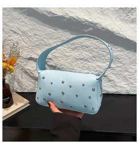 Detail showing light blue lychee pattern leather bag with silver metallic rivets on the side