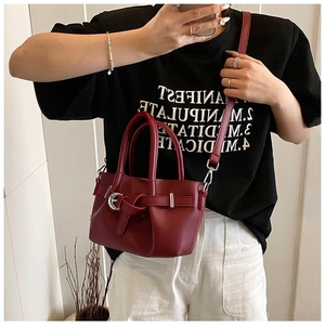 Détail du sac seau bordeaux en similicuir avec boucle argentée et fine bandoulière