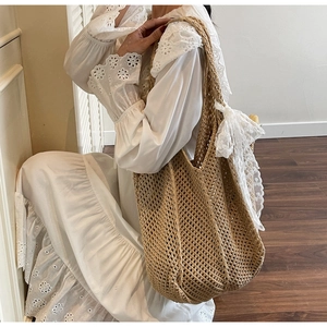 Détail du sac cabas au crochet kaki avec motif ajouré et décoration de nœud en dentelle