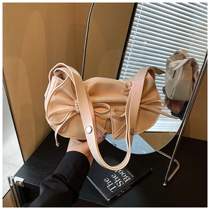 Dettaglio borsa hobo a pieghe crema stile balletto con fiocco in pelle e tracolla larga