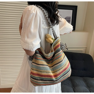 Dettaglio di borsa tote in paglia a righe colorate con tulipani gialli decorativi