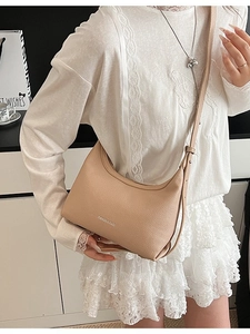 Chic light brown leather dumpling bag with silver lettering and thin shoulder strap