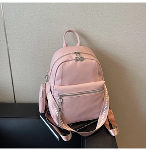 Pink backpack detail showing litchi grain texture and wide geometric pattern strap