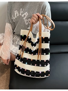 Sac fourre-tout en tricot rayé avec perles colorées et anses en cuir sur un modèle