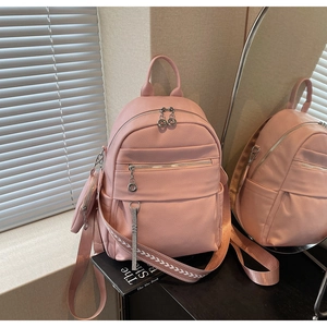Detail of pink lychee leather backpack with silver hardware and small round coin purse
