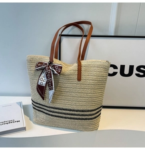 Close-up of straw tote bag with black stripes and bear print silk scarf detail