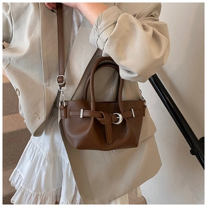 Détails d'un sac seau marron foncé avec boucle argentée et coutures de précision