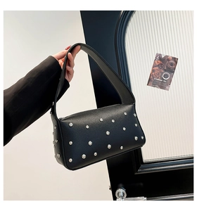 Dettaglio della borsa in pelle martellata nera con rivetti metallici argentati decorativi